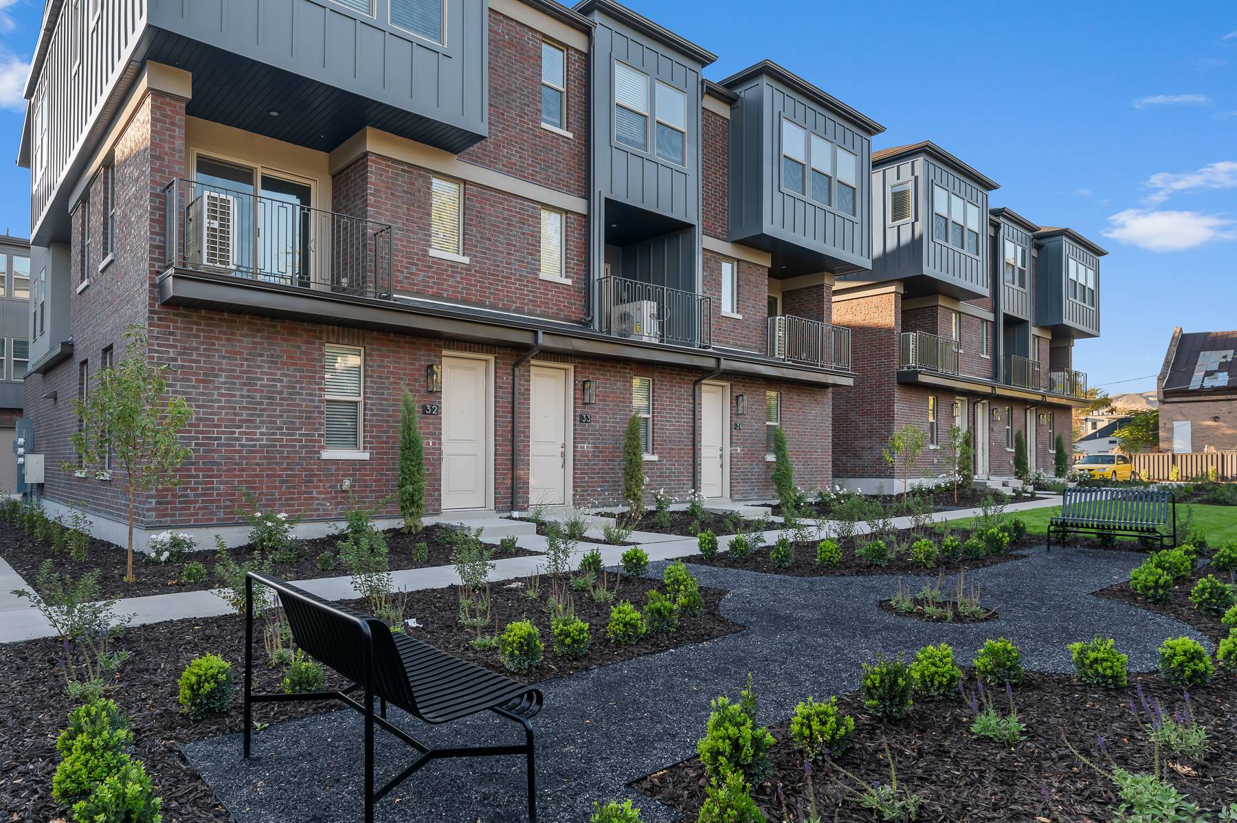 Landscaped courtyard with benches in front of Liberty Wells townhomes